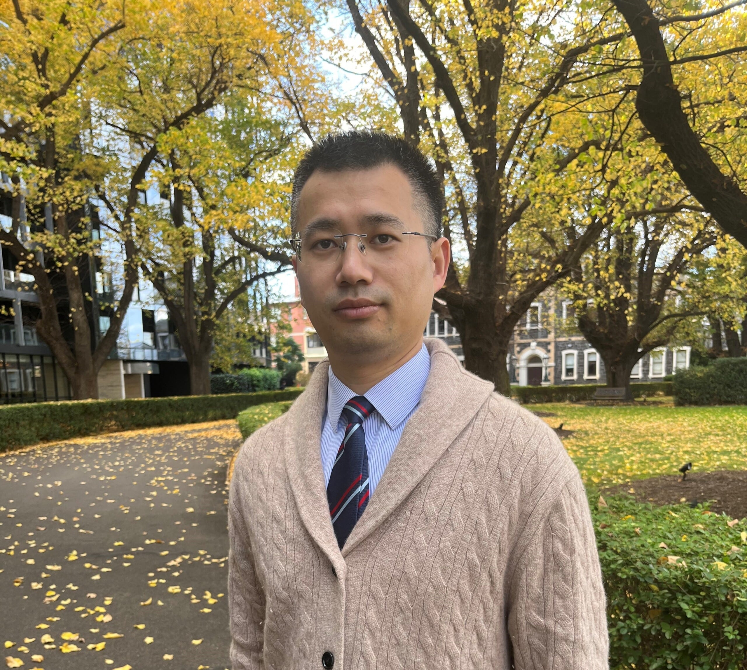 A headshot of Dr Xu in an outdoor setting with trees