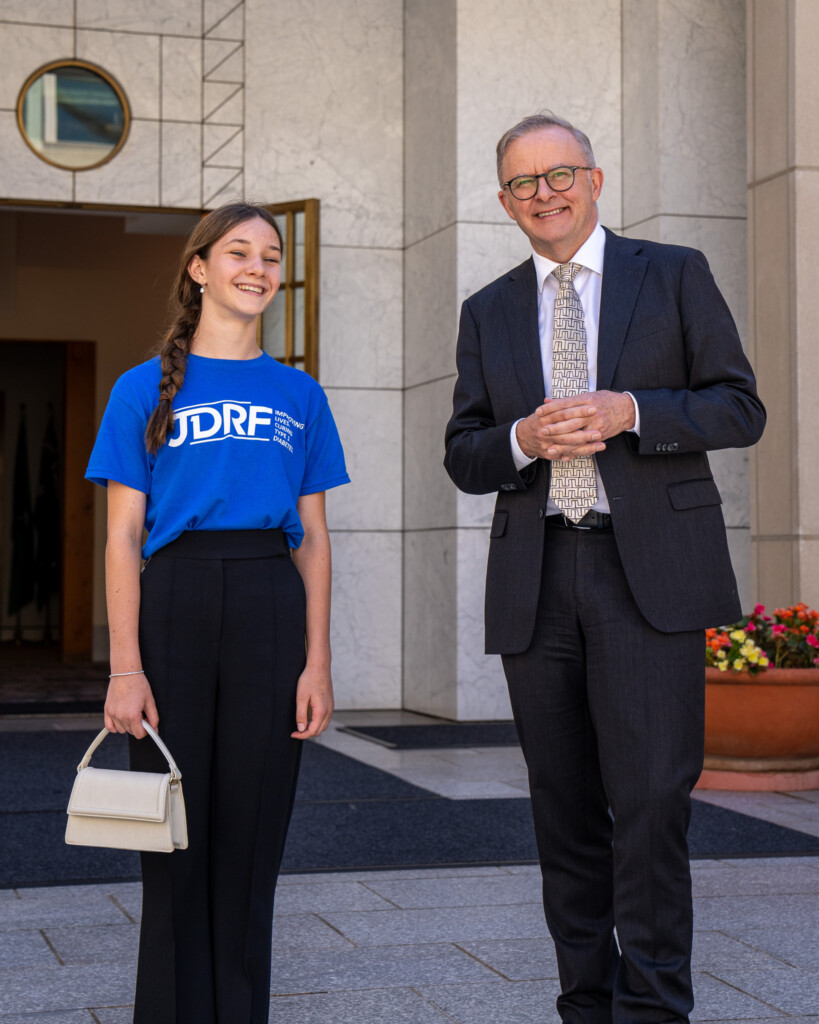 JDRF advocate, Giselle, standing next to Prime Minister, Anthony Albanese. Both are smiling.